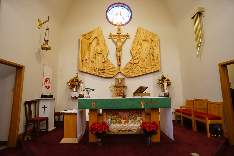 Front altar with large wood crucifix hanging behind it